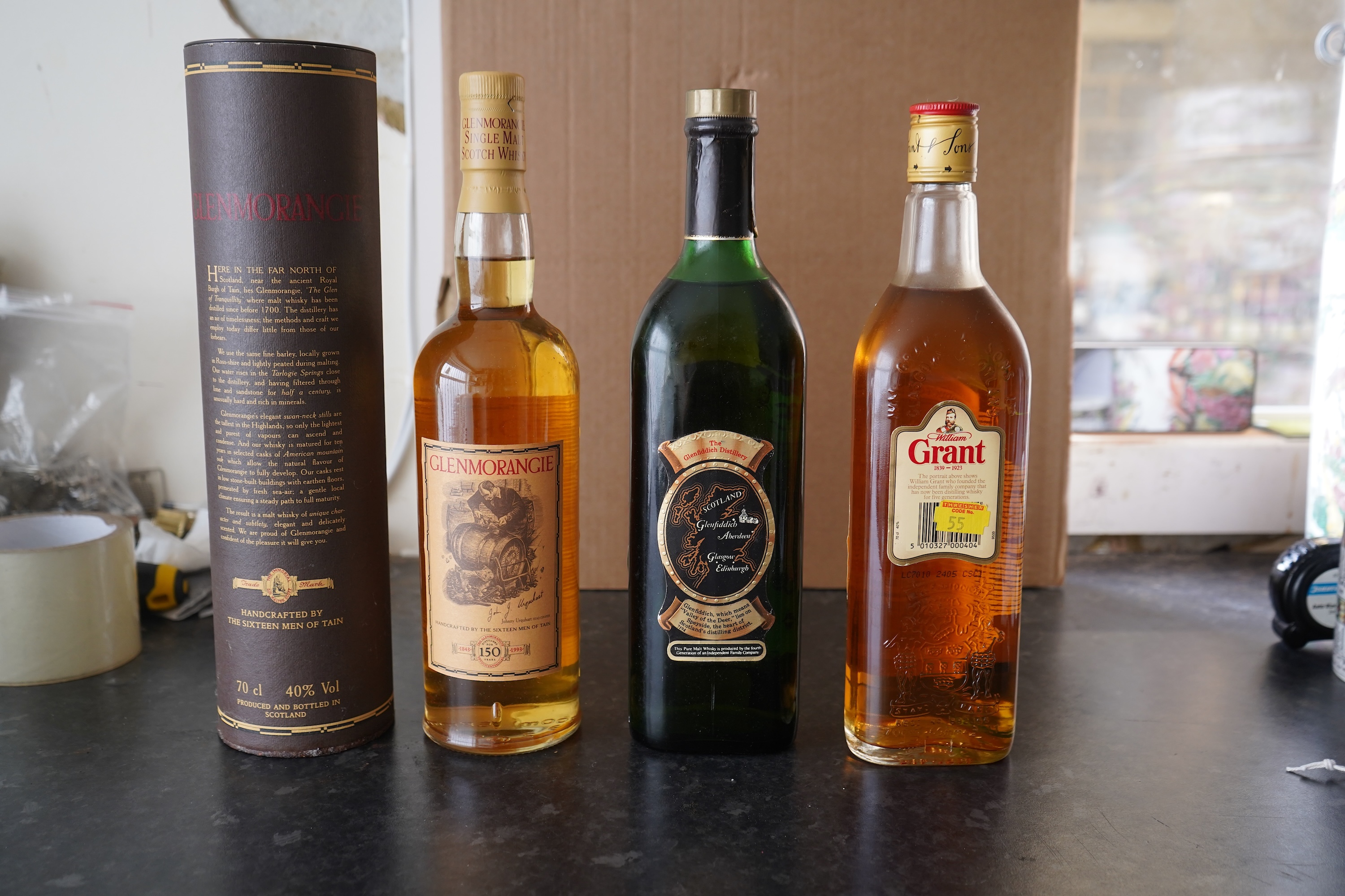 Three bottles of malt whisky: Glenmorangie, Glenfiddich and Grants